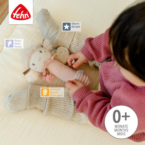 Baby im rosa Pullover hält den Stabgreifling Fee mit Glow-in-the-dark-Lamm-Rassel- Features: leuchtet im Dunkeln, Rassel, Quietsche, fördert Feinmotorik; geeignet ab 0+ Monaten-perfektes Geschenk für die Kleinsten.