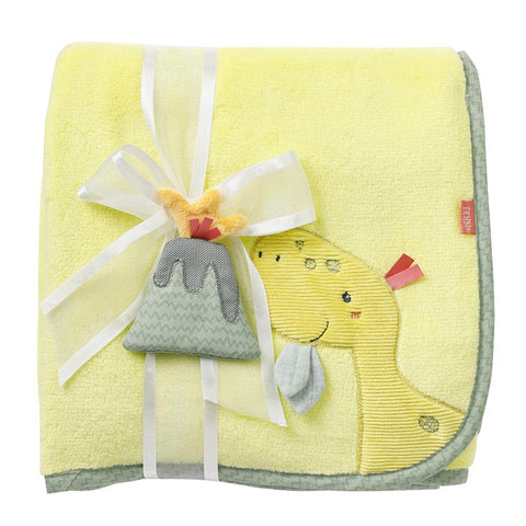 Eine gefaltete gelbe Plüschdecke Dino Babydecke mit einer gestickten Giraffe, verziert mit einem Band und einem Plüsch-Accessoire in Form eines Vulkans.