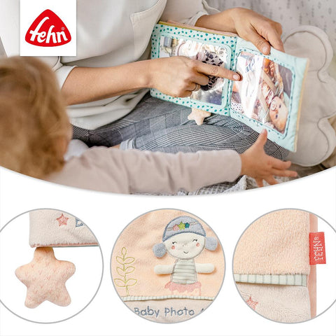 Ein Erwachsener und ein Baby bewundern das weiche Fotoalbum Meerjungfrau mit sternförmigen Details, einem gestickten Mädchen und kuscheligem Stoff im charmanten Meerjungfrauen-Design. Das Fehn-Logo befindet sich oben links - ideal als Geschenk zur Geburt.