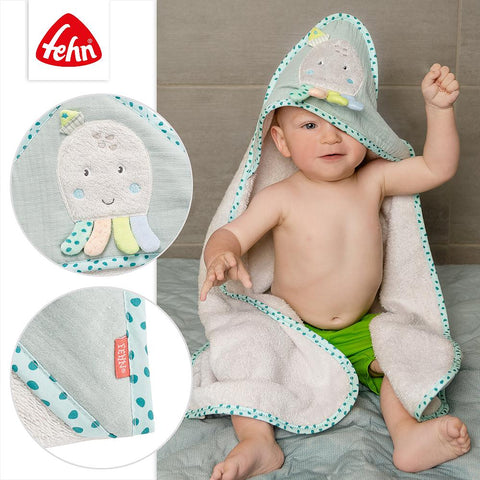 Ein Baby sitzt auf dem Boden, eingewickelt in das Kapuzenbadetuch Oktopus. Zwei Nahaufnahmen zeigen den weichen Frottee-Stoff und das Tehn-Markenschild.