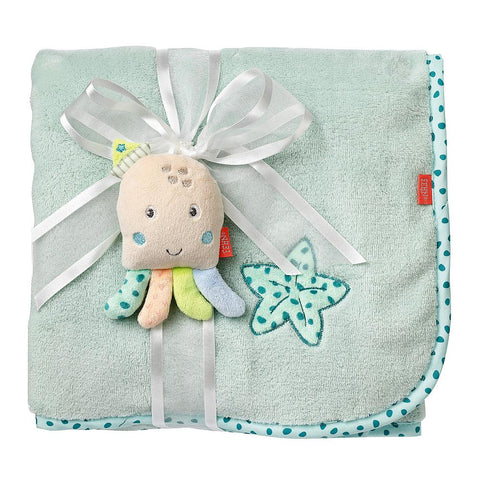 Eine mintgrüne Kuscheldecke Oktopus mit einem aufgenähten Stern in Petrol, einer Tupfenborte und einem Plüschkraken, alles mit einer weißen Schleife gebunden - ein bezauberndes Babygeschenk.