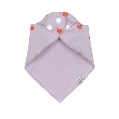 Das Dreieckstuch Baby (2 Stk) - Bandana, Happy Rascals Herz ist ein hellviolettes Baby-Bandana-Lätzchen aus Bio-Baumwolle mit einem orangefarbenen Herzmotiv, zwei weißen Druckknöpfen und einem kleinen Logo-Anhänger unten rechts.
