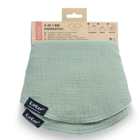 Ein hellgrünes, strukturiertes 3 in 1 Lätzchen (Spucktuch, Latz, Halstuch) von KipKep mit einem Pappanhänger mit Details und zwei schwarzen Markenanhängern am Baby-Halstuch.