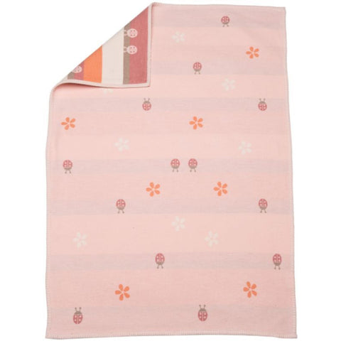 Die Babydecke Lena Käfer (GOTS) in Altrosa, 75x100cm, zeigt Marienkäfer- und Blumenmuster. In einer Ecke ist das gestreifte rosa-orange-weiße Unterteil sichtbar. GOTS-zertifiziert für besondere Hautfreundlichkeit.