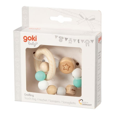 Der Greifling Elastik Stern, türkis von Goki besteht aus Holz und Silikon mit pastellfarbenen Perlen und wird in einer weißen Goki Baby Box mit Klarsichtfenster präsentiert.