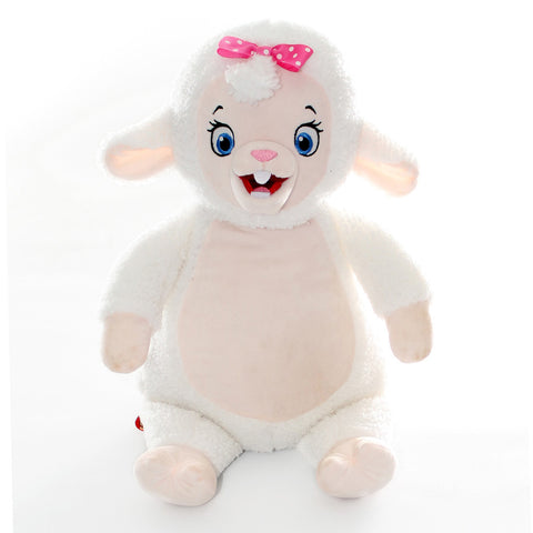 A Signature Schaf Plüschtier mit weißem Fell, rosa Ohren, pinker Schleife, blauen Augen und zwei Zähnen sitzt aufrecht vor weißem Hintergrund. Dieses Kuscheltier ist auch für die Maschinenwäsche geeignet.