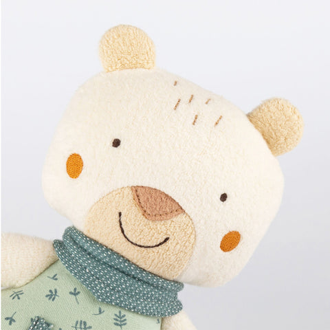 Die Baby Spieluhr Bär ist ein weicher, cremefarbener Plüschteddy mit einzigartigem Design, gestickten Gesichtszügen, orangefarbenen Wangen und einem grün gemusterten Schal für extra Kuschelkomfort vor weißem Hintergrund.