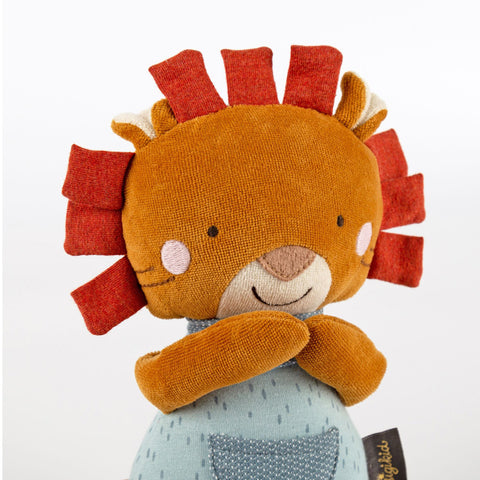 Der Baby Spieluhr Löwe ist ein Plüschlöwe mit braunem Gesicht, roter Stoffmähne, gestickten Details und einem blauen Outfit mit Tasche - perfekt zum Personalisieren und Kuscheln.