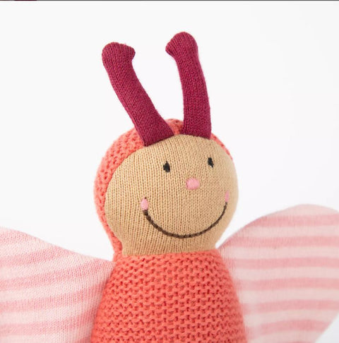 Der Strick-Greifling Schmetterling (20 cm) ist ein gestricktes Schmetterlingsspielzeug mit einem lächelnden Gesicht, rosa gestreiften Flügeln, weinroten Fühlern und einem weichen Baumwollstrick-Körper, der auf einem schlichten weißen Hintergrund abgebildet ist.