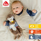 Ein Baby liegt auf einem Bett und kuschelt mit dem Schmusetuch Otter. Oben links erscheint das Fehn-Logo mit drei Symbolen für Kuscheln, Spielen, Trösten - Sehen, Tasten, Schlafen - in Deutsch, Englisch und Spanisch.