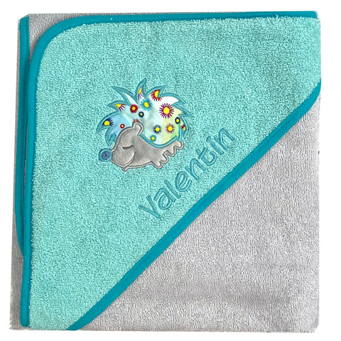 Das Kapuzenbadetuch chrom/blaugrün 100x100cm aus 100% Baumwolle zeigt einen niedlichen Igel mit Schnuller und bunten Blumen. Die Bestickung mit dem Namen "Valentin" verleiht ihm eine persönliche Note.