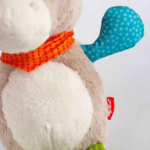 Eine Nahaufnahme der Baby Minispieluhr Esel zeigt den weichen beigen Plüsch, den weißen Bauch, das orange gepunktete Halstuch, die blauen gepunkteten Ohren und den roten Anhänger.